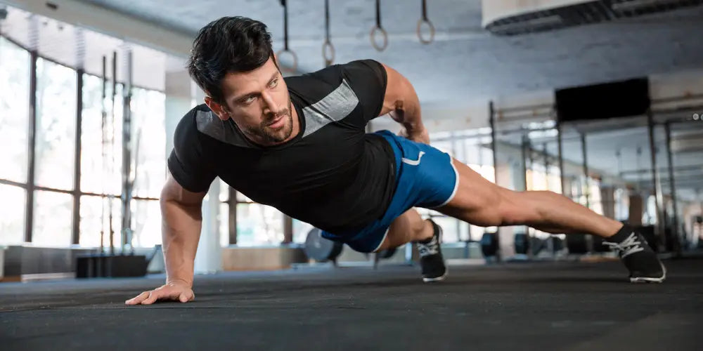 man in fitness apparel doing one armed push up